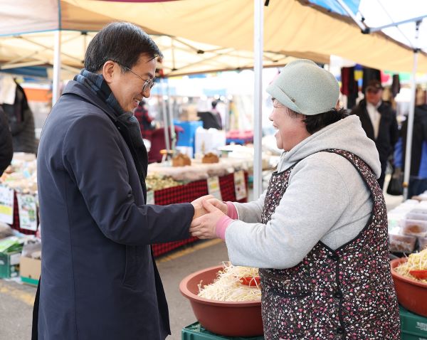 김포 북변 5일장을 방문한 김동연 지사(왼쪽)가 시장 상인과 악수를 나누고 있다.